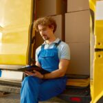 Professional young male courier providing parcel management before shipping