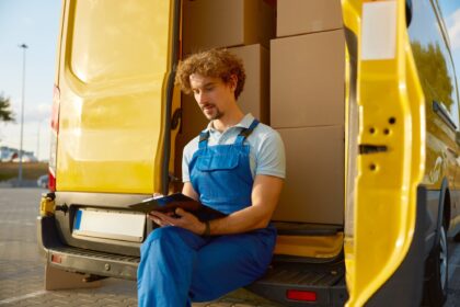 Professional young male courier providing parcel management before shipping