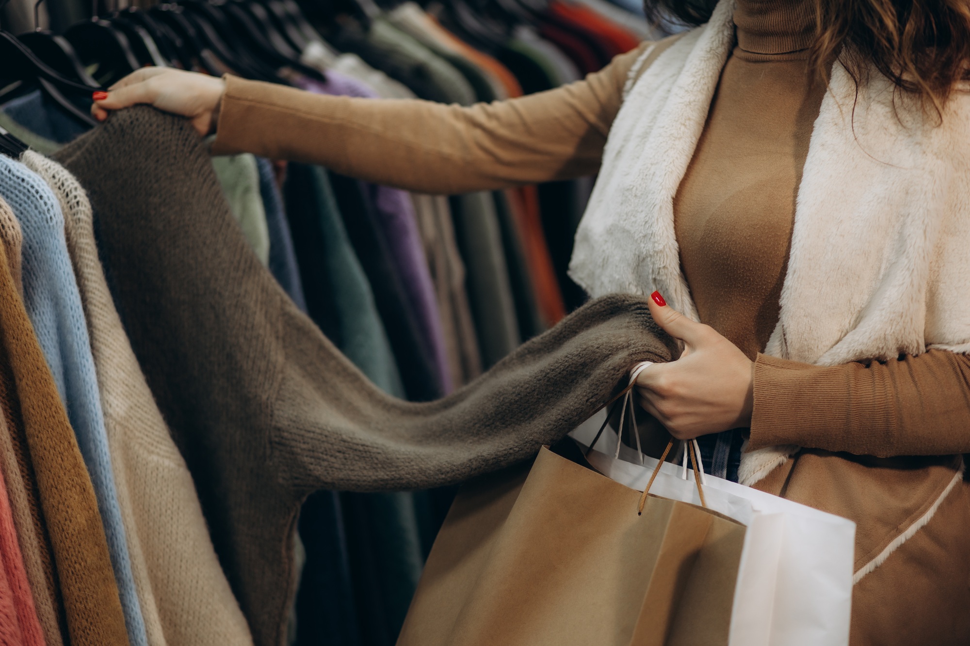 Woman Shopping for Warm Sweater at Fashionable Clothing Store
