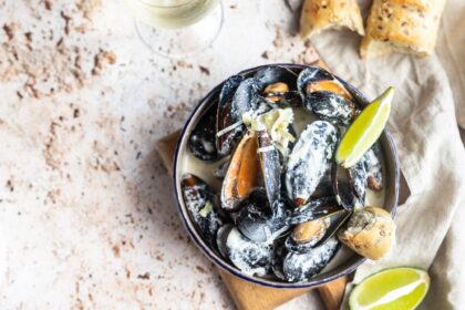Blue mussels in wine sauce with lime and bread. Stew mussels in wine, leek and blue cheese. Seafood