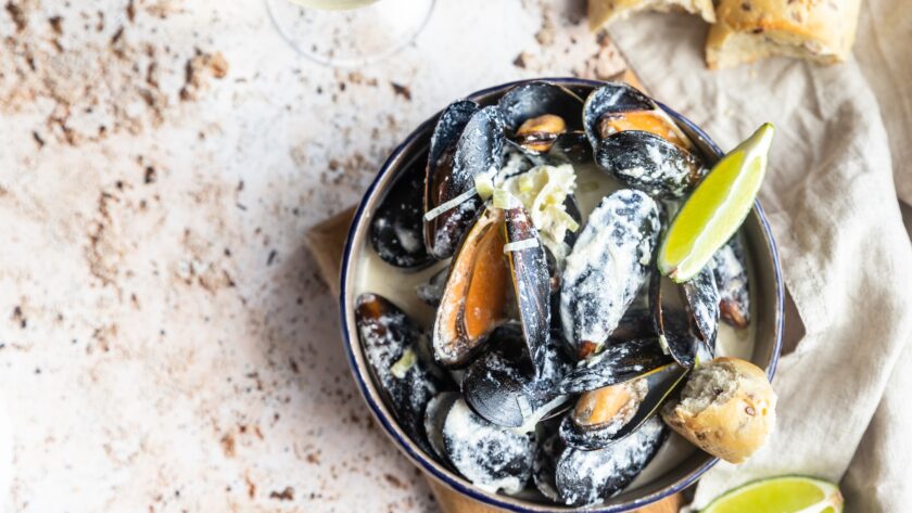 Blue mussels in wine sauce with lime and bread. Stew mussels in wine, leek and blue cheese. Seafood