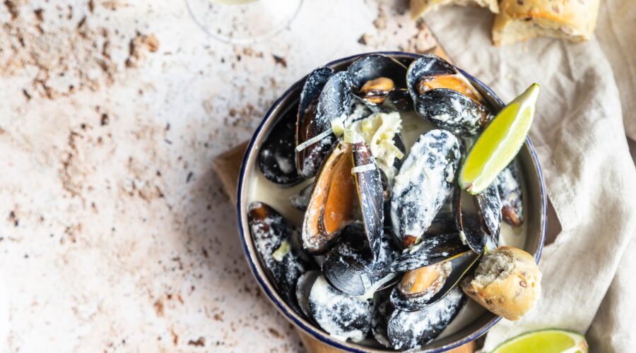 Blue mussels in wine sauce with lime and bread. Stew mussels in wine, leek and blue cheese. Seafood