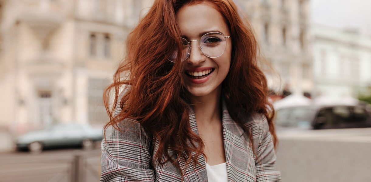 Young woman in good humor poses outside