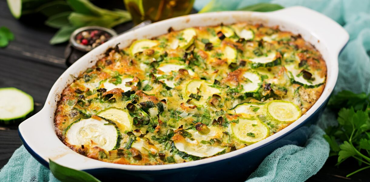 Zucchini casserole with eggs, milk, cheese and greens herbs