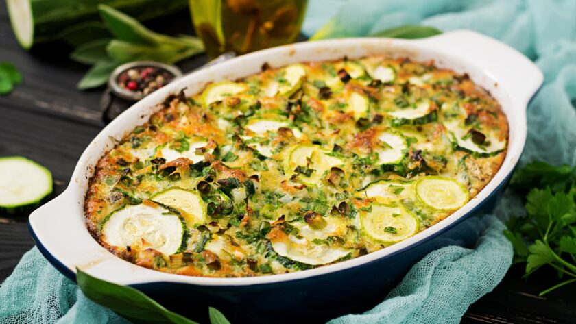 Zucchini casserole with eggs, milk, cheese and greens herbs