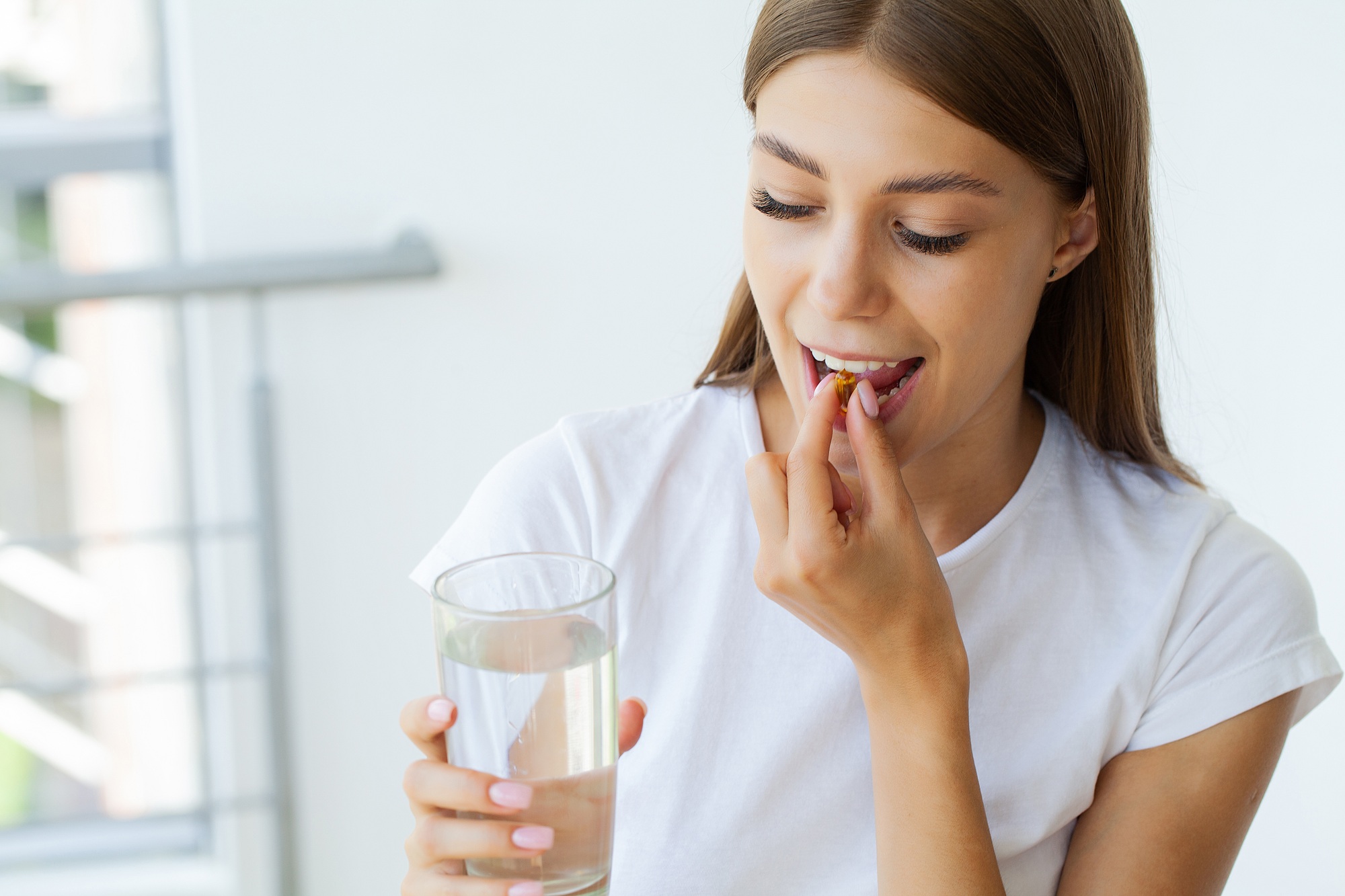 Beautiful Woman Holding Fish Oil Pill In Hand