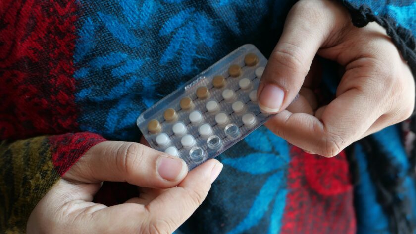 women hand holding birth control pills close up