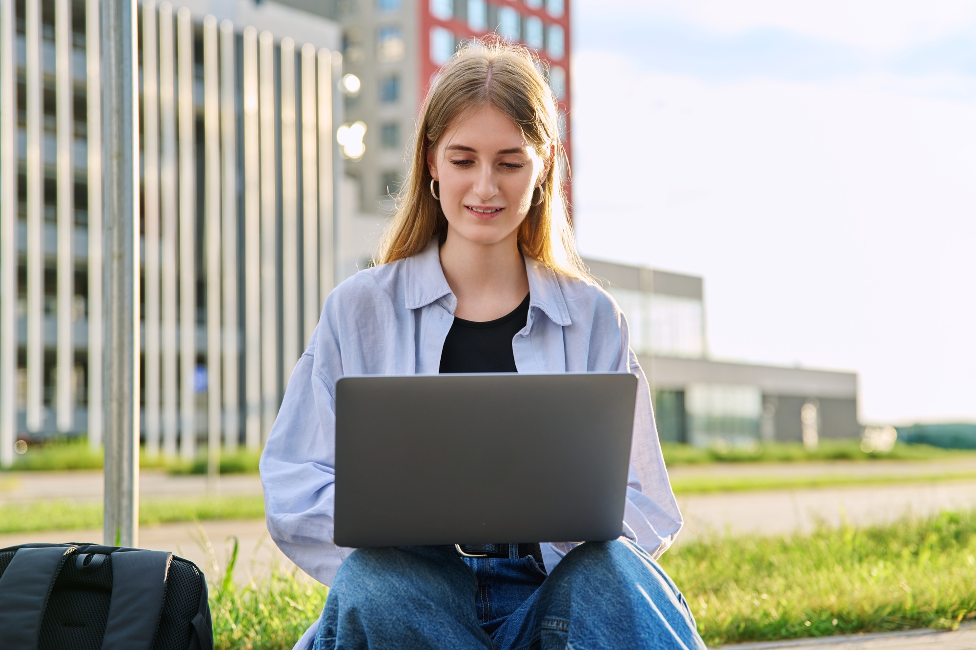 Young female college student using laptop computer outdoor